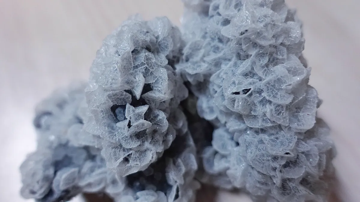Pale Quartz Crystal Cluster With Glassy Translucent Plates Close view of a pale blue quartz crystal cluster with thin translucent plates catching soft light